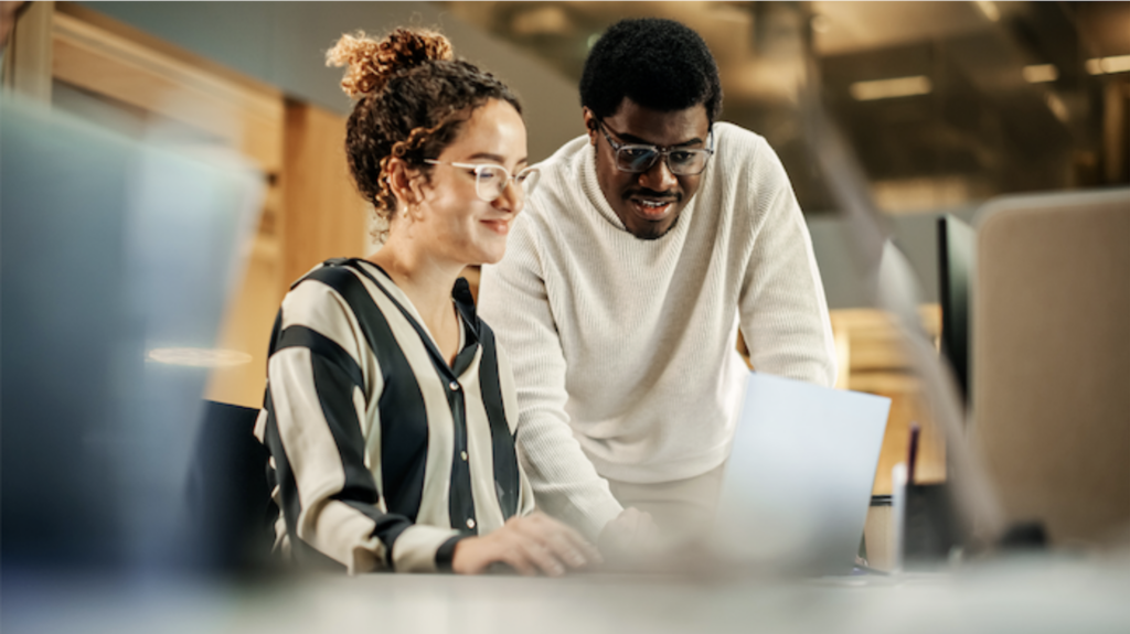 Two people looking at a laptop screen